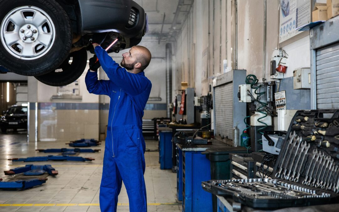 A man in a blue suit checks a car.