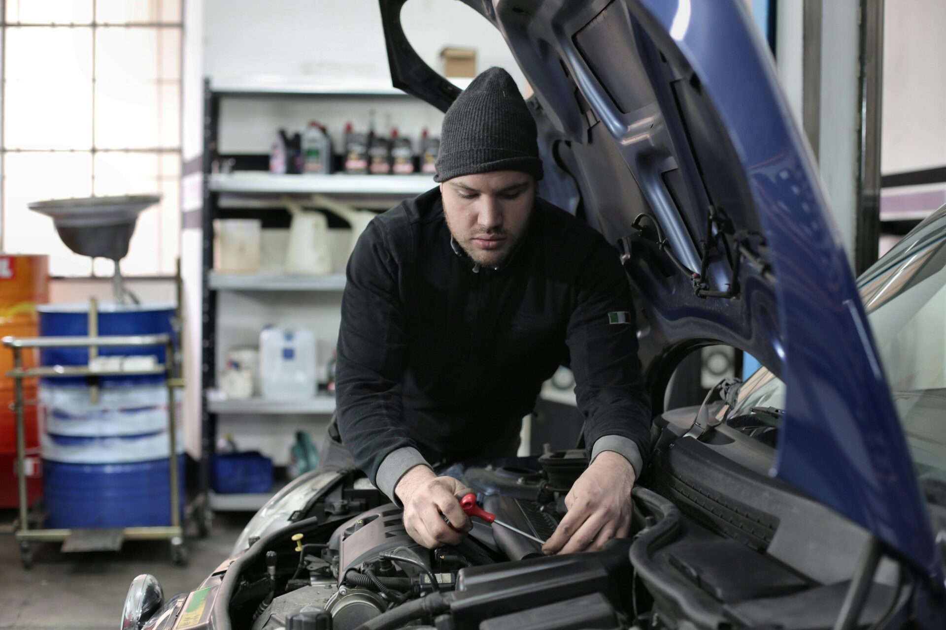 A car technician works on repairing a car engine.
