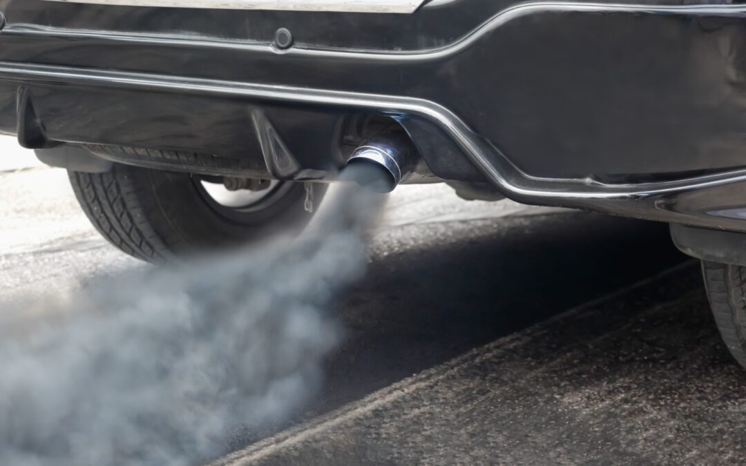 Vehicle exhaust pipe emitting smoke from his exhaust on the road